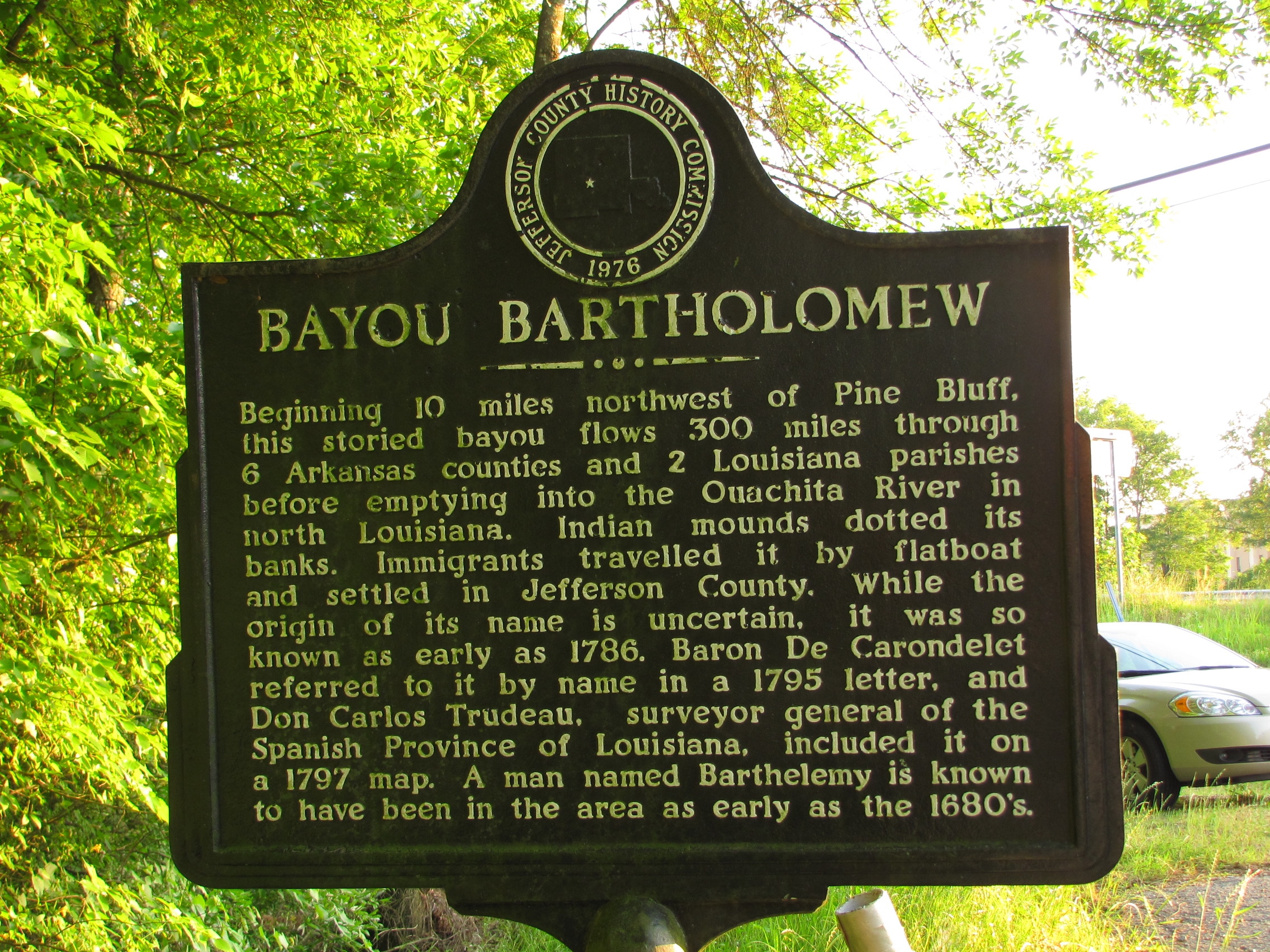 Historical marker for Bayou Bartholomew that reads: "Beginning 10 miles northwest of Pine Bluff, this storied bayou flows 300 miles through 6 Arkansas counties and 2 Louisiana parishes before emptying into the Ouachita River in north Louisiana. Indian mounds dotted its banks. Immigrants travelled it by flatboat and settled in Jefferson County. While the origin of its name is uncertain, it was so known as early as 1786. Baron De Carondelet referred to it by name in a 1795 letter, and Don Carlos Trudeau, surveyor general of the Spanish Province of Louisiana, included it on a 1797 map. A man named Barthelemy is known to have been in the area as early as the 1680's."