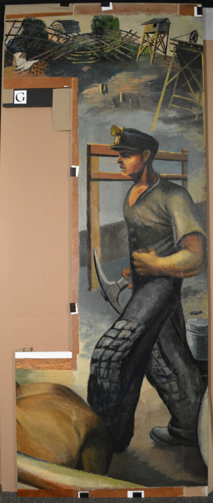 A mural scene of a coal miner walking with a pick-axe in one hand and his other hand clenched into a fist. This is after conservation efforts were completed.